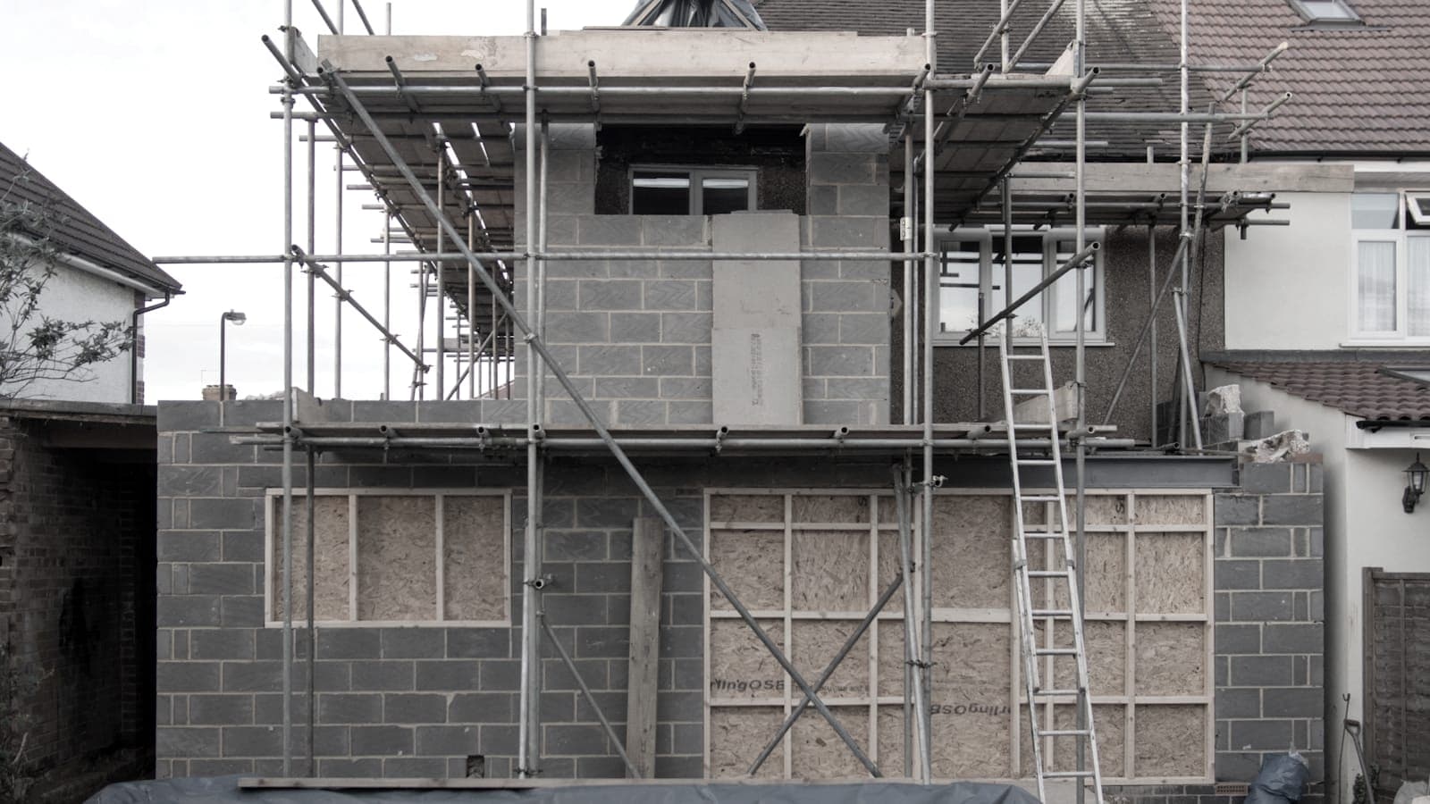 Two-storey house extension under construction in blockwork with scaffolding