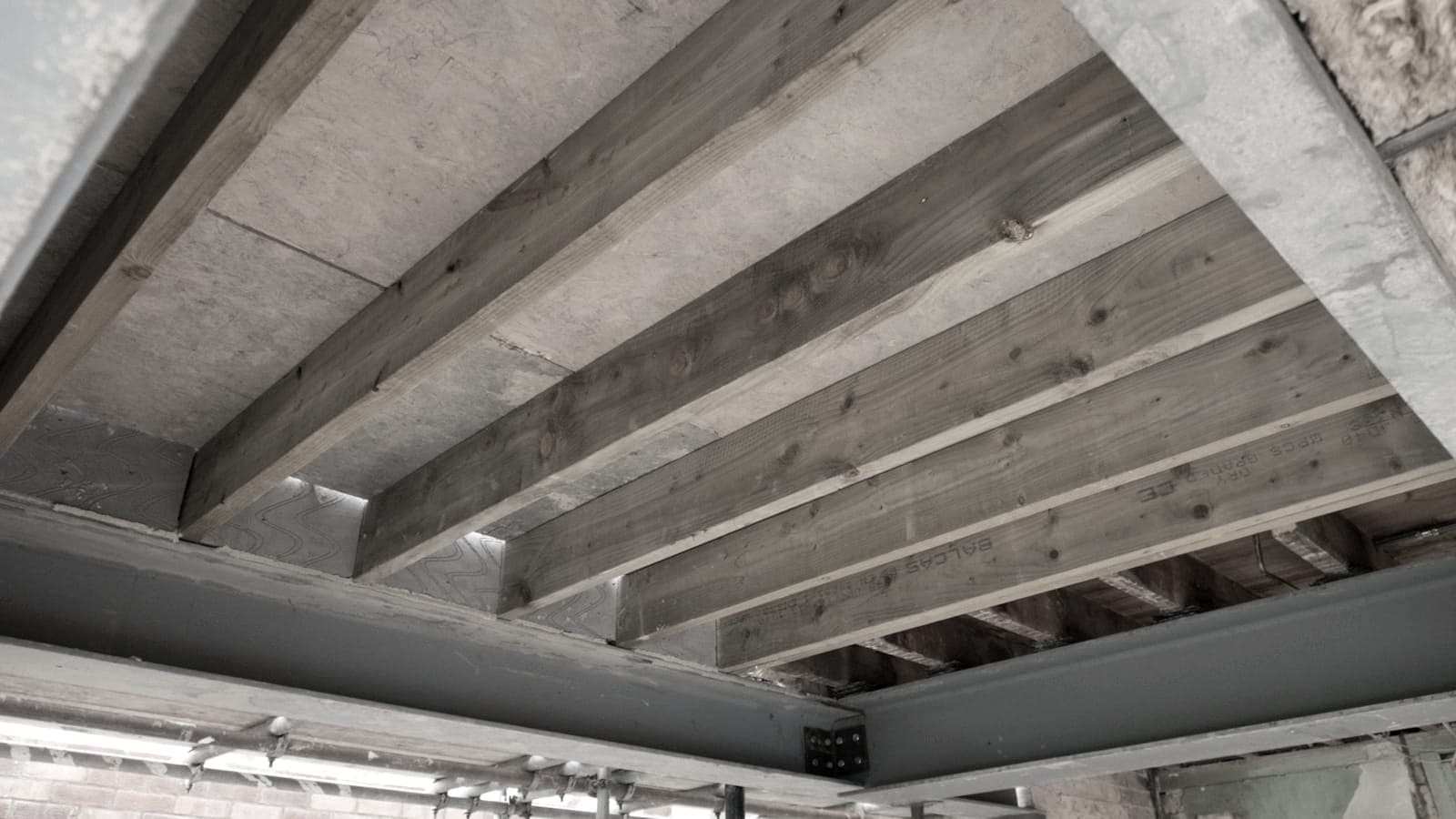 Timber floor joists spanning onto a steel beam