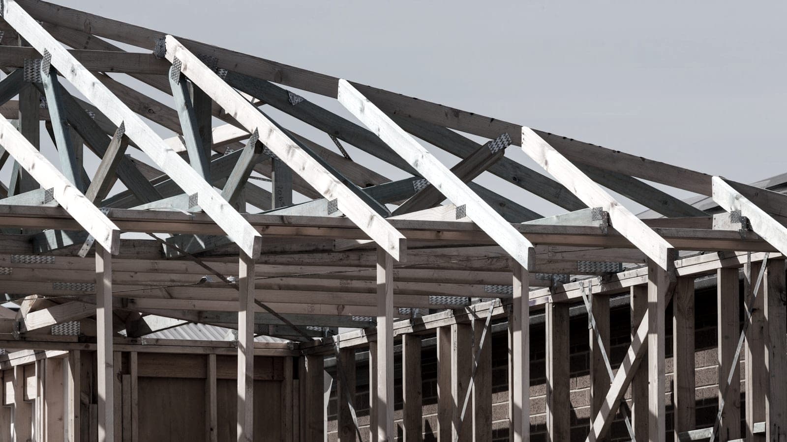 Two-storey domestic extension under construction with materials stacked on site